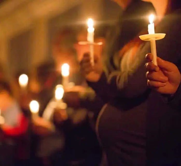 hands holding vigil candles